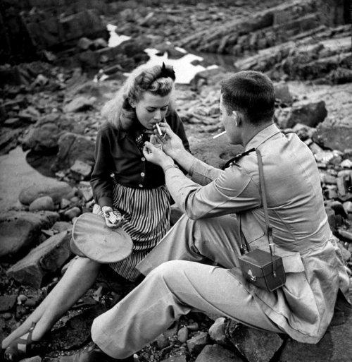 A US Navy flier and his date smoking on the coast of Morocco. Casablanca, 1943